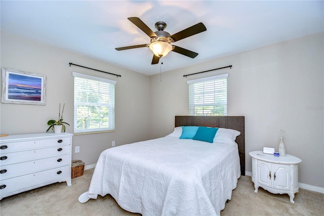 carpeted bedroom featuring ceiling fan and multiple windows