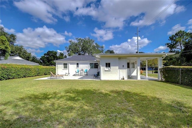 back of property with a lawn and a patio area