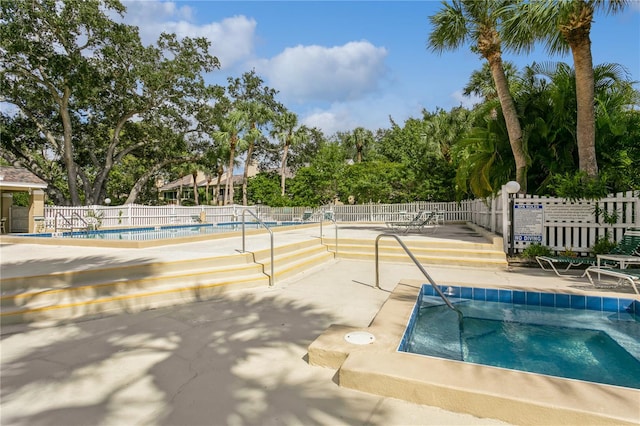 view of pool with a hot tub and a patio area