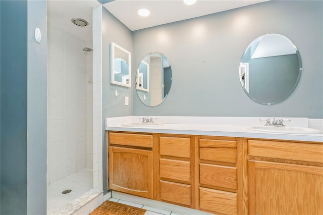 bathroom featuring tile patterned floors, vanity, and a tile shower