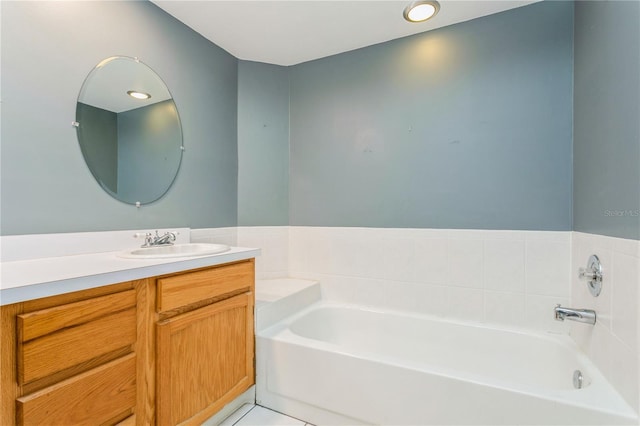 bathroom with a washtub, vanity, and tile patterned floors