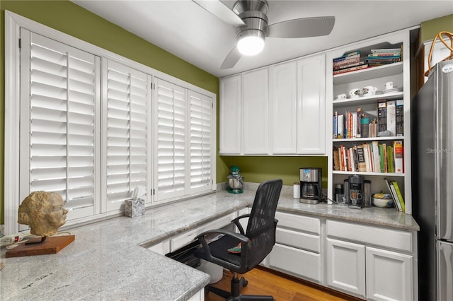 office area with built in desk and ceiling fan