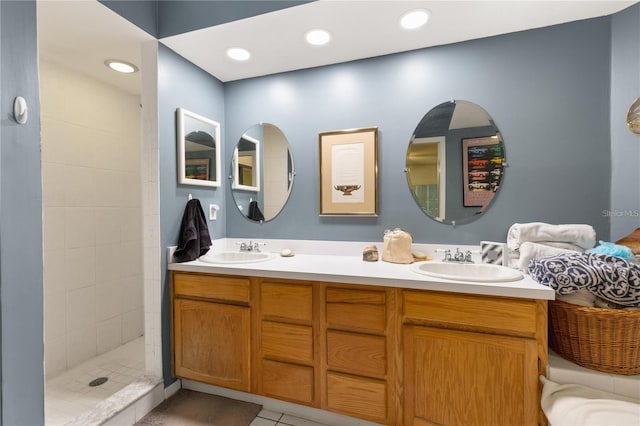 bathroom with vanity, a tile shower, and tile patterned floors