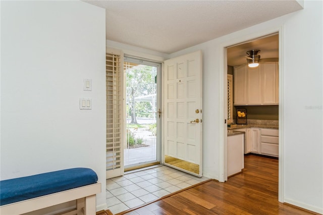 entryway featuring light hardwood / wood-style flooring and a textured ceiling