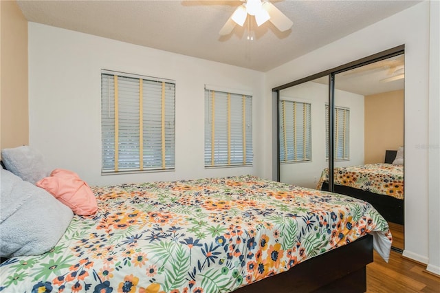 bedroom with hardwood / wood-style floors, a closet, a textured ceiling, and ceiling fan