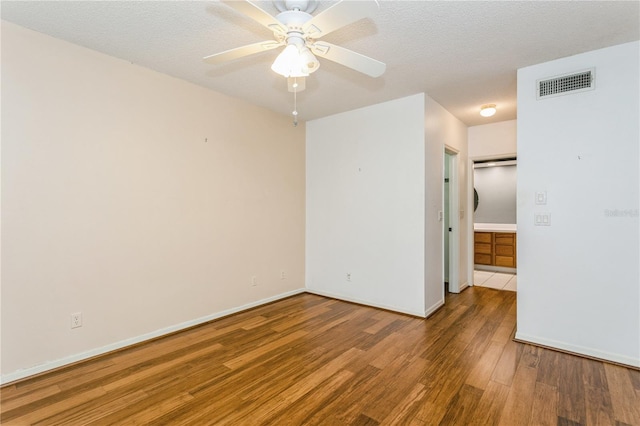 unfurnished room with wood-type flooring, ceiling fan, and a textured ceiling