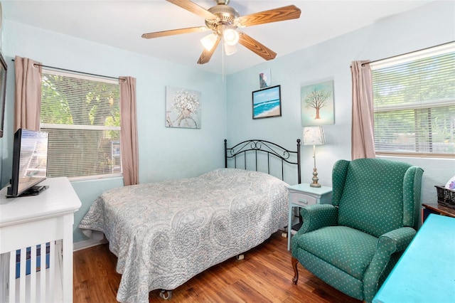 bedroom featuring multiple windows, hardwood / wood-style floors, and ceiling fan