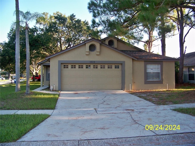 ranch-style home featuring a garage and a front yard