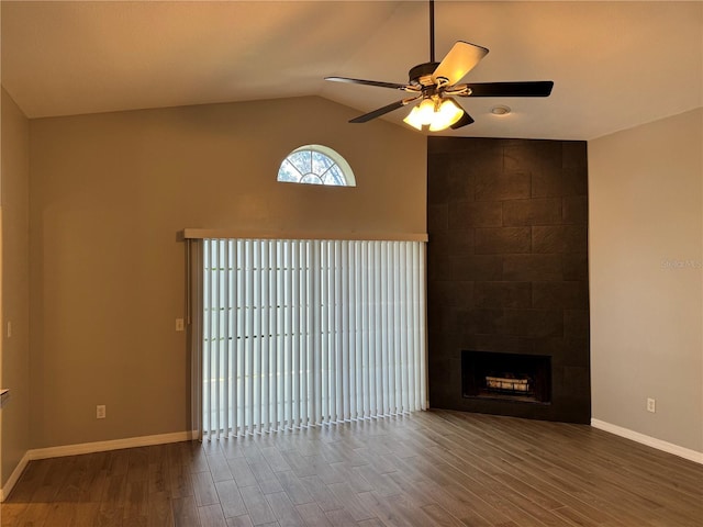 unfurnished living room featuring wood-type flooring, lofted ceiling, a fireplace, and ceiling fan