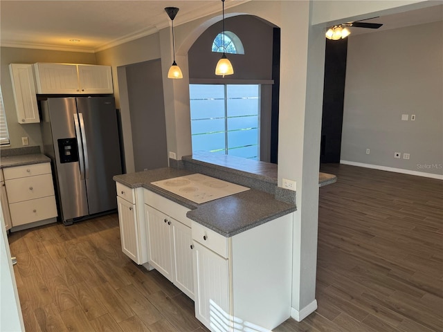 kitchen with ornamental molding, stainless steel refrigerator with ice dispenser, dark hardwood / wood-style flooring, and white cabinetry