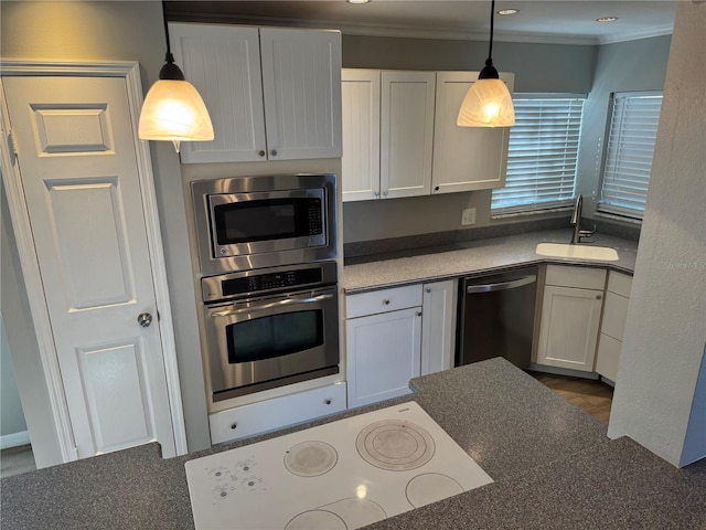 kitchen featuring decorative light fixtures, stainless steel appliances, sink, and white cabinetry