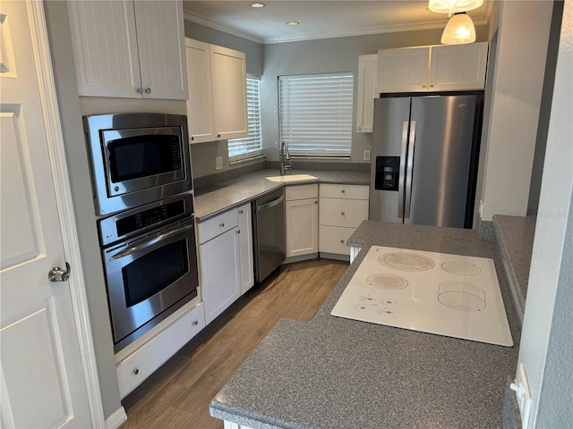 kitchen featuring stainless steel appliances, white cabinets, hardwood / wood-style flooring, and sink