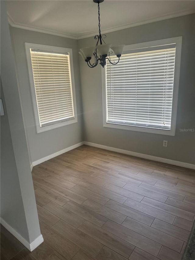 unfurnished dining area with an inviting chandelier, light wood-type flooring, and a wealth of natural light