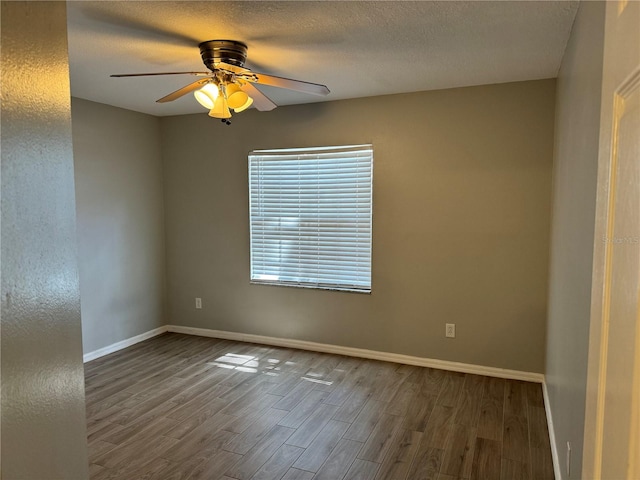 spare room with a textured ceiling, dark wood-type flooring, and ceiling fan