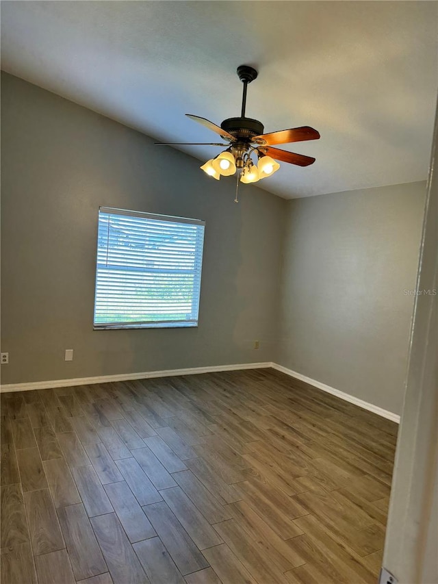 spare room featuring lofted ceiling, ceiling fan, and dark wood-type flooring