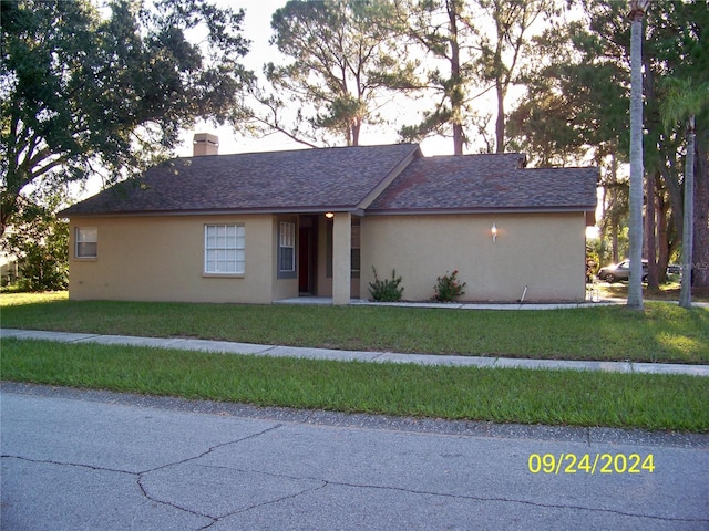 single story home with a front lawn