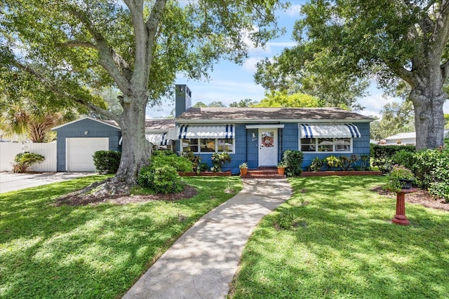 single story home with a front lawn, an outdoor structure, and a garage