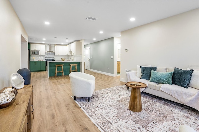 living room with sink and light hardwood / wood-style flooring