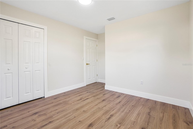 unfurnished bedroom featuring a closet and light wood-type flooring