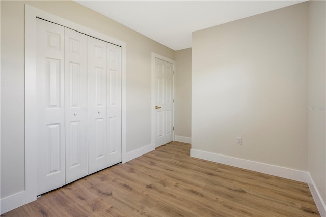 unfurnished bedroom with light hardwood / wood-style floors and a closet