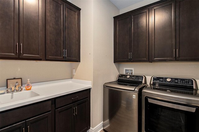 laundry room with washer and dryer, cabinets, and sink