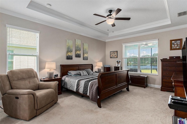 bedroom with ornamental molding, a tray ceiling, visible vents, and light colored carpet