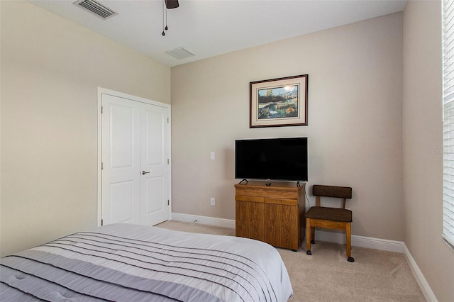 bedroom with multiple windows, a closet, light colored carpet, and ceiling fan