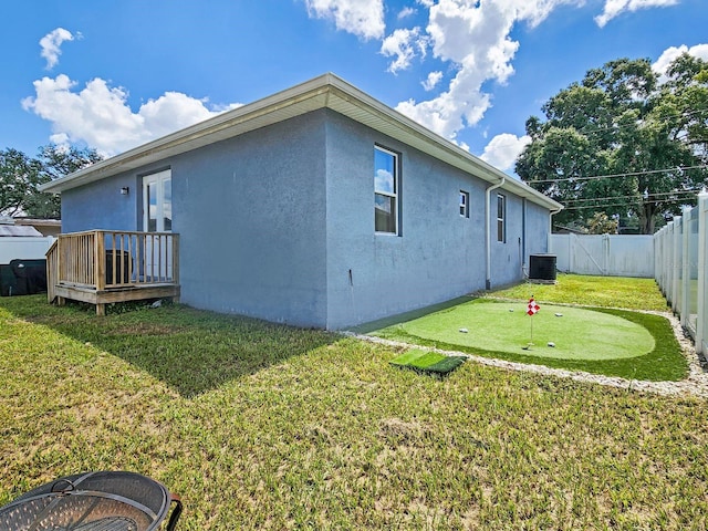 rear view of property featuring a yard and cooling unit