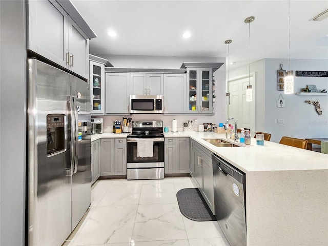 kitchen with sink, decorative light fixtures, gray cabinets, kitchen peninsula, and stainless steel appliances