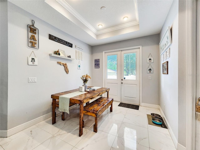 dining area with french doors, crown molding, and a raised ceiling