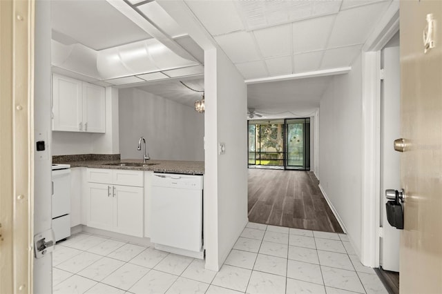 kitchen featuring dark stone countertops, sink, light wood-type flooring, white cabinets, and white appliances