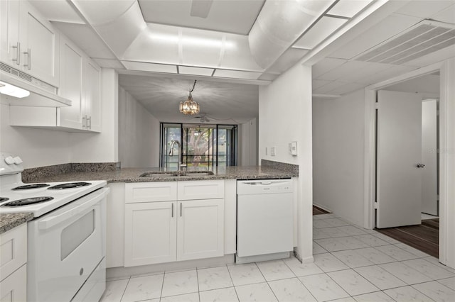 kitchen featuring white appliances, a notable chandelier, white cabinetry, and sink