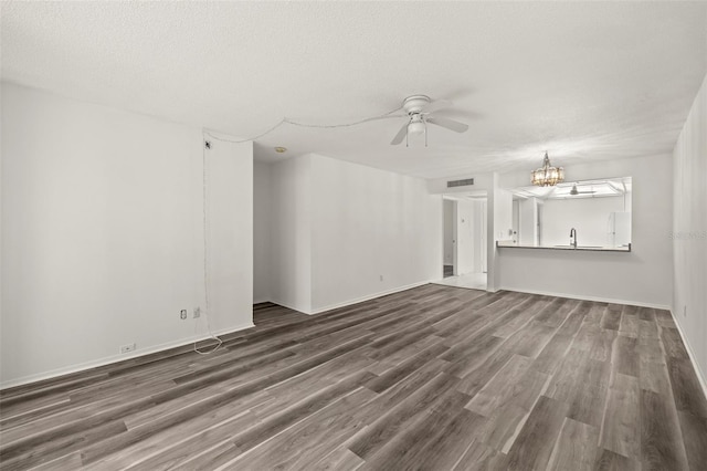 unfurnished living room featuring a textured ceiling, dark hardwood / wood-style floors, and ceiling fan