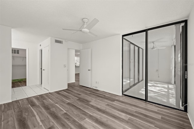 interior space featuring light hardwood / wood-style flooring, a textured ceiling, and ceiling fan