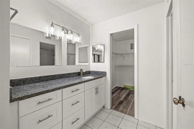 bathroom with vanity, a textured ceiling, and hardwood / wood-style floors