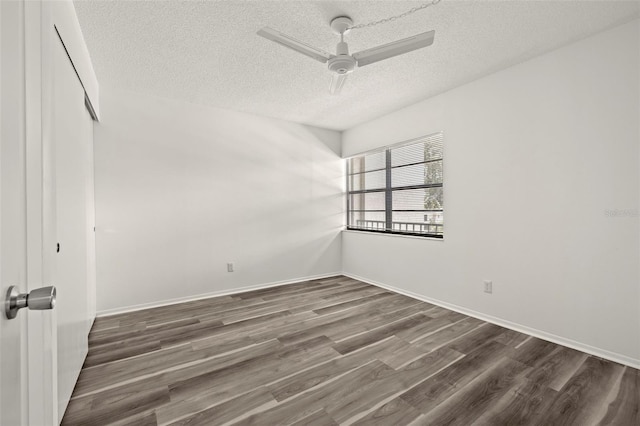 empty room with dark wood-type flooring, ceiling fan, and a textured ceiling