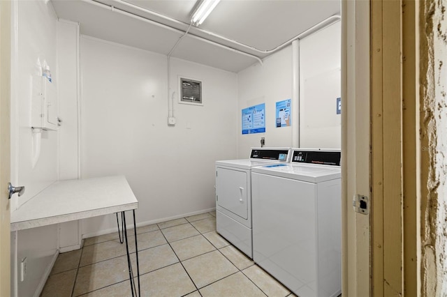 laundry room featuring washer and dryer and light tile patterned flooring