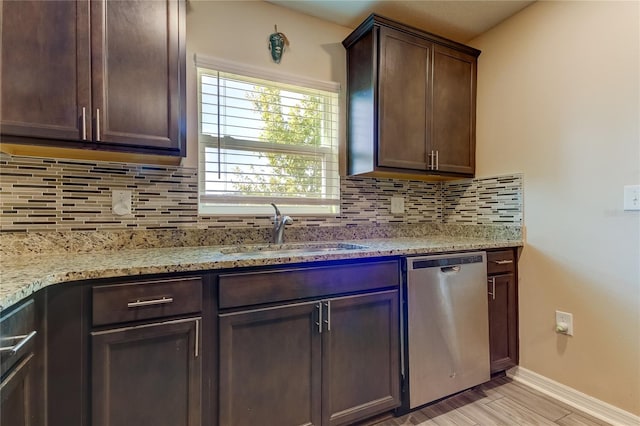 kitchen featuring dark brown cabinets, light stone counters, sink, and stainless steel dishwasher