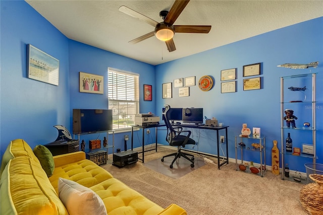 carpeted home office with ceiling fan and a textured ceiling