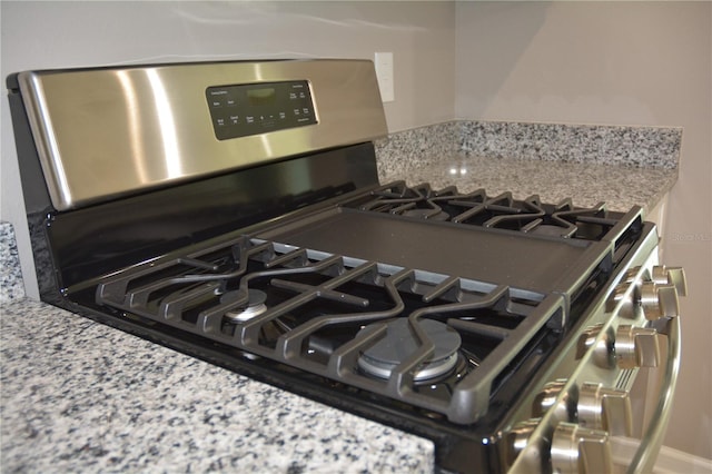 details with light stone countertops and stainless steel gas range