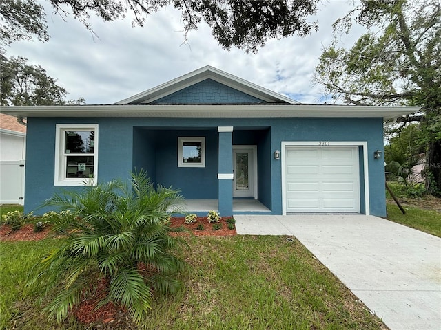 view of front of property with a porch, a garage, and a front lawn