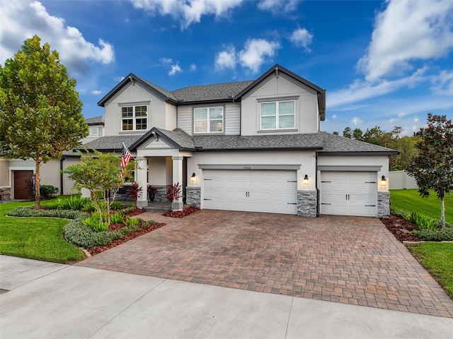 craftsman house with stone siding, decorative driveway, stucco siding, and an attached garage