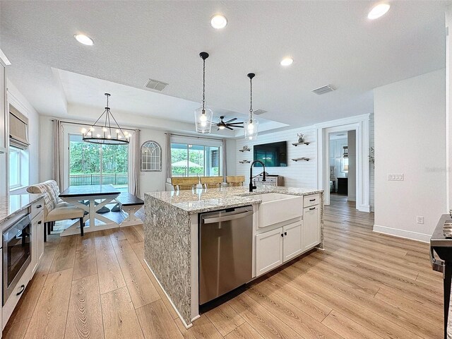 kitchen with a sink, visible vents, appliances with stainless steel finishes, and light wood finished floors