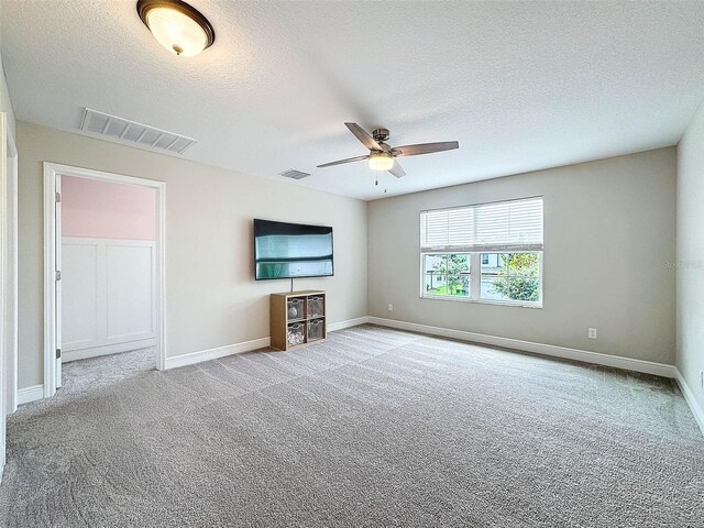 unfurnished living room with visible vents, carpet floors, and a textured ceiling