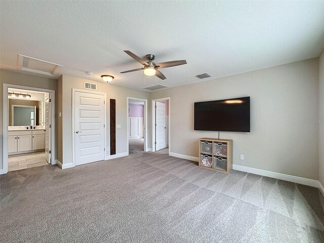 unfurnished living room with visible vents, attic access, and carpet flooring