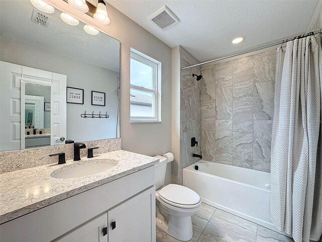 full bath with vanity, visible vents, shower / tub combo, a textured ceiling, and toilet