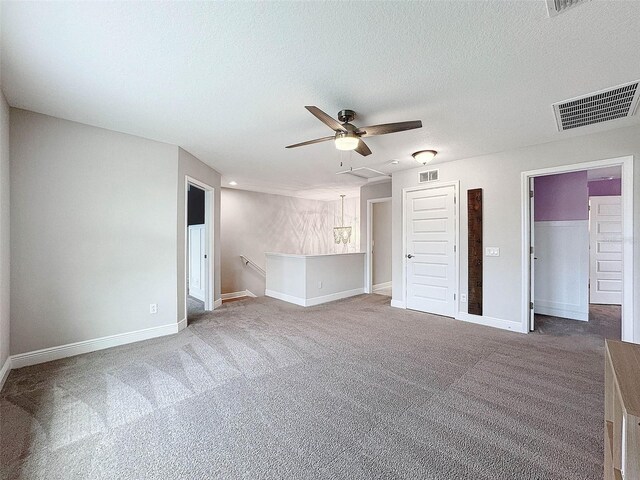 carpeted spare room featuring ceiling fan, baseboards, visible vents, and a textured ceiling