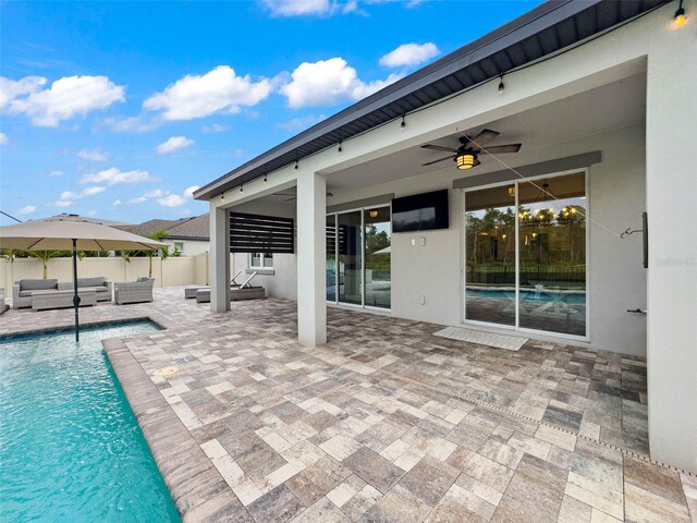 view of pool featuring a patio, fence, outdoor lounge area, a fenced in pool, and ceiling fan