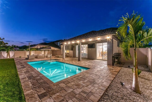 view of swimming pool featuring a patio, a fenced in pool, a fenced backyard, outdoor lounge area, and a grill