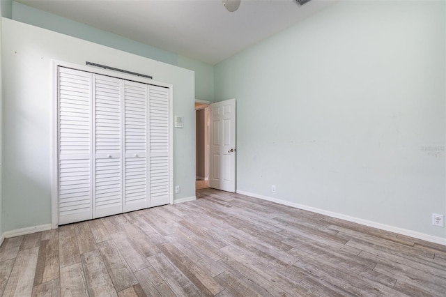 unfurnished bedroom with a closet and light wood-type flooring